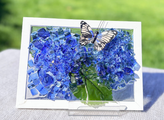 Card with blue flowers and a butterfly on a grassy background